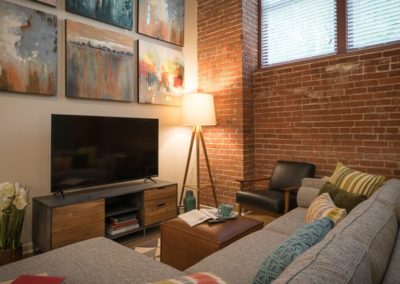 Apartment living room with brick accent wall at Shadyside Commons in Pittsburgh, PA